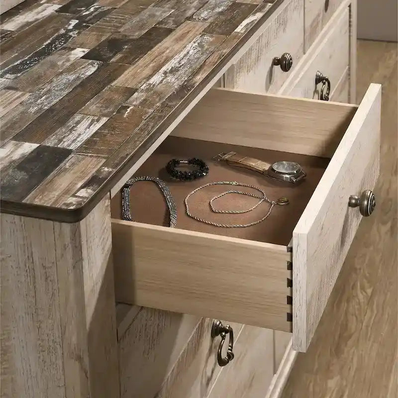 Chambre à coucher contemporaine avec finition blanchie comprenant un lit traîneau, une commode, un miroir et deux tables de chevet.