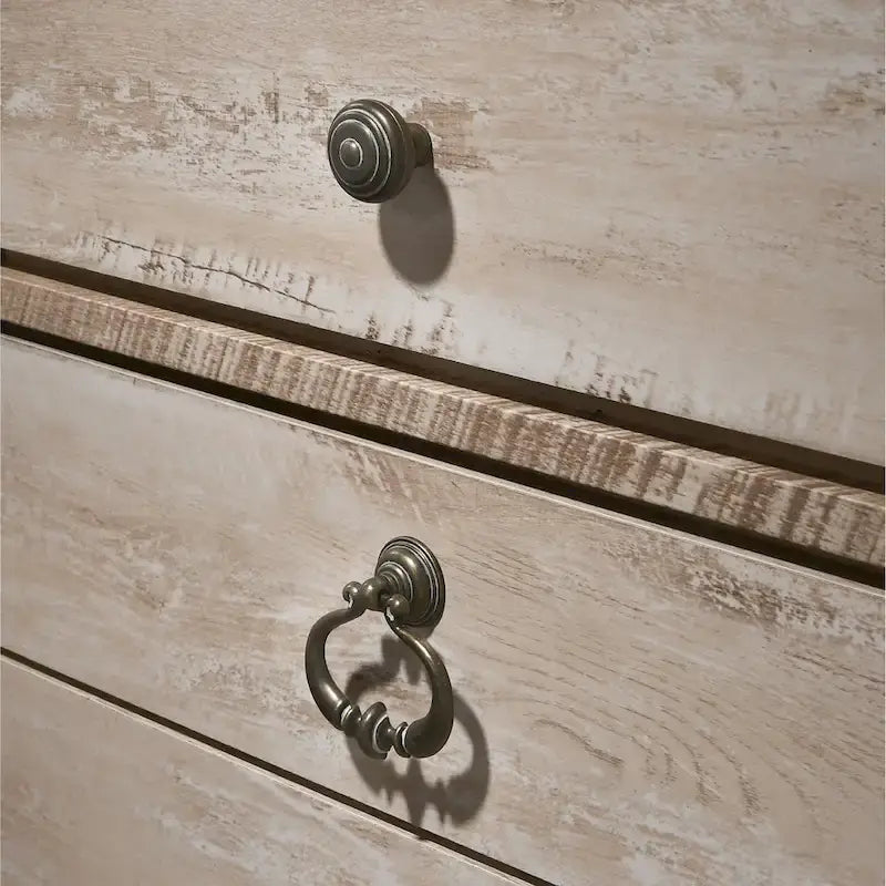 Chambre à coucher contemporaine avec finition blanchie comprenant un lit traîneau, une commode, un miroir et deux tables de chevet.